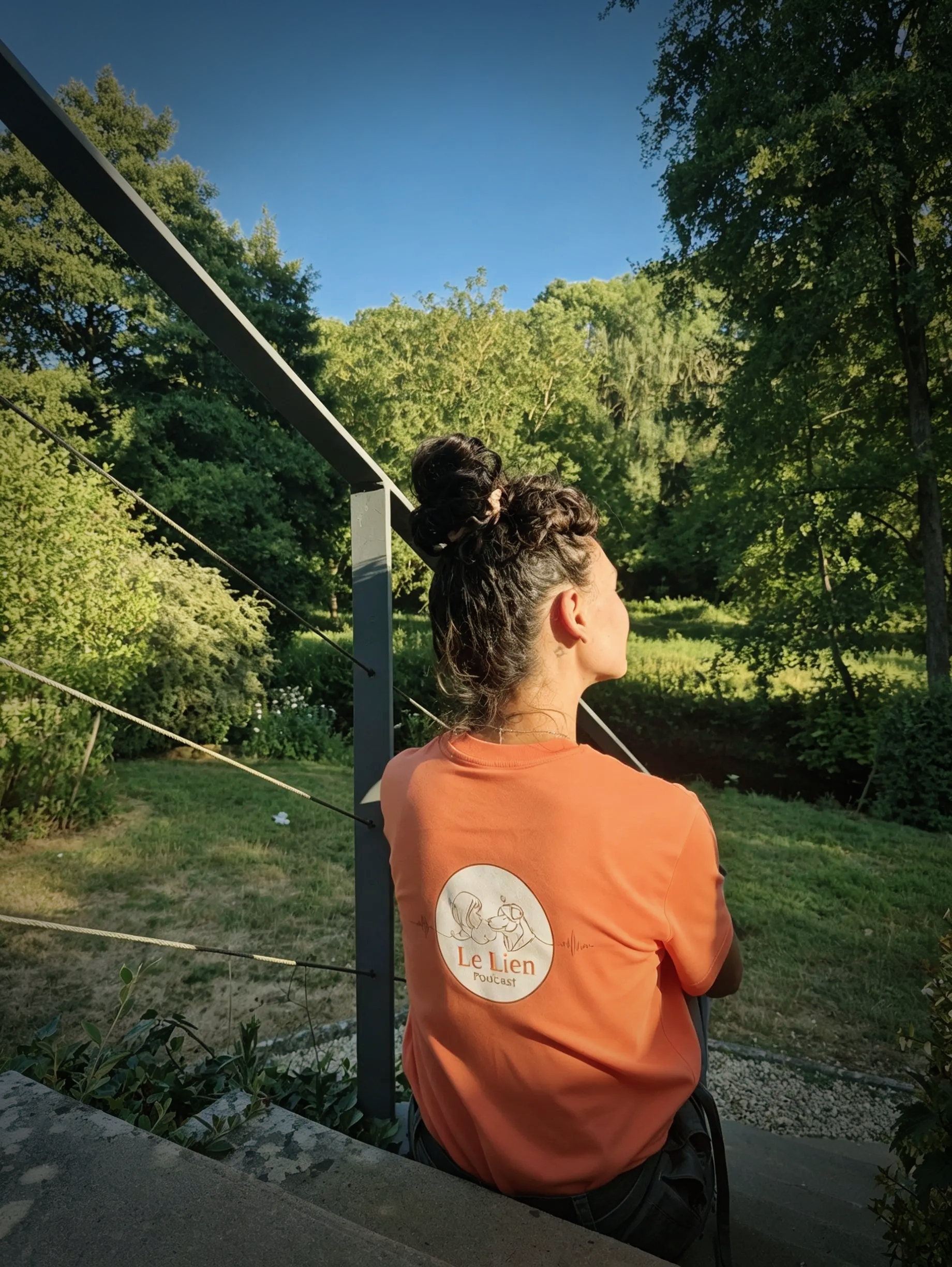 Célia de dos avec le logo Le Lien dans un jardin